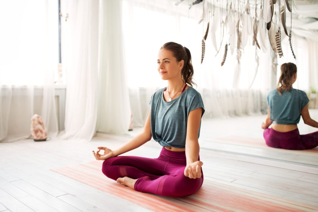 woman meditating in lotus pose at yoga studio